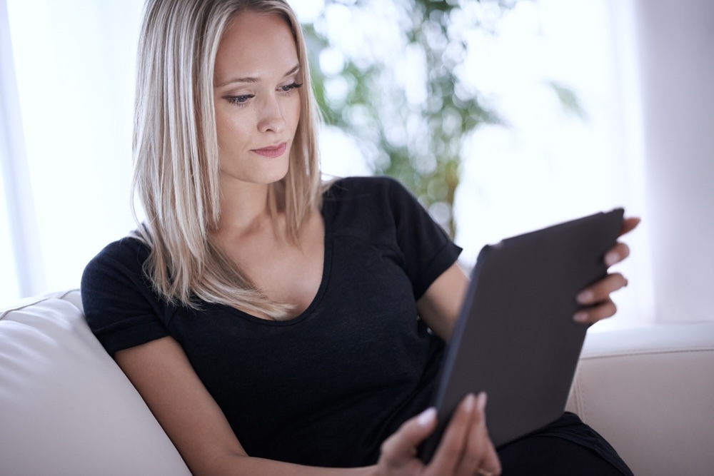 Woman looking at a mobile tablet choosing a gynecologist in Orange County
